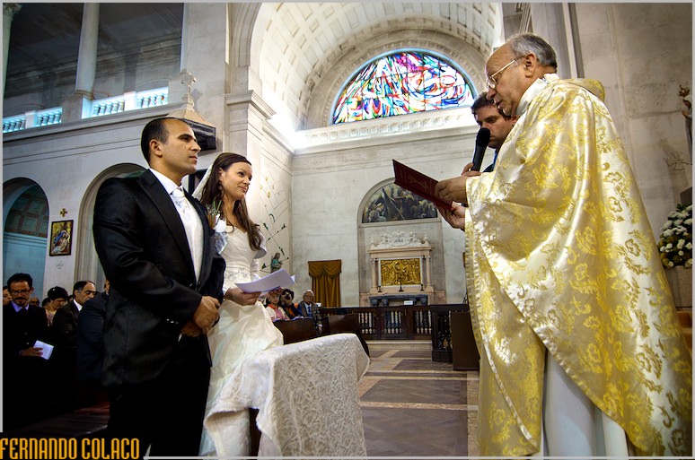 O padre em frente dos noivos, no começo da cerimónia das alianças do casamento.