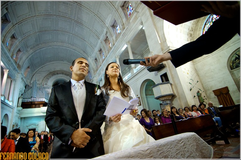 Os noivos, na Basílica de Fátima, com os convidados por detrás, no juramento do casamento.