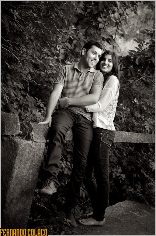 A noiva, com o noivo junto dela, sentado, sobre uma pequena ponte em Sintra.