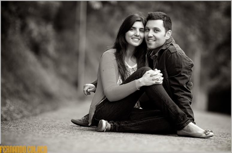 O casal, na sessão de pré casamento,  sentado no meio da estrada para Monserrate em Sintra.