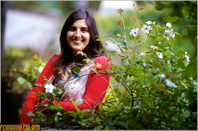 A noiva, na sessão de pré-casamento, entre flores silvestres num muro da serra de Sintra.