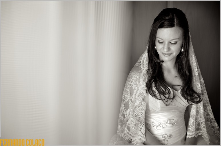 Ready and with the veil over her shoulders, the bride smiles.