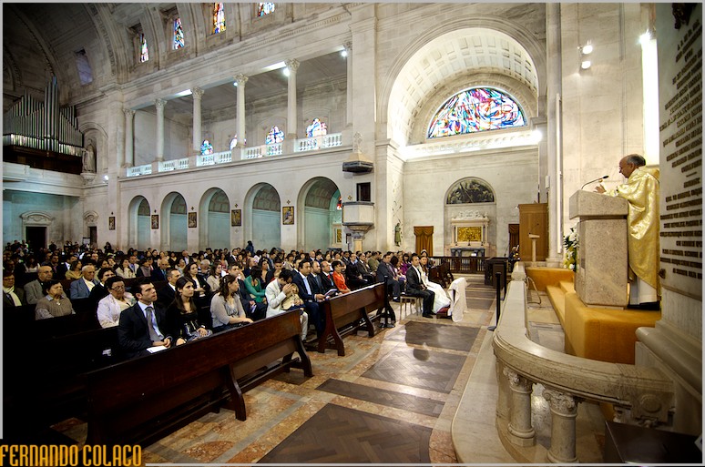 Interior of the Basilica of Mafra, seen from the side, with guests, bride and groom and officiating priest.