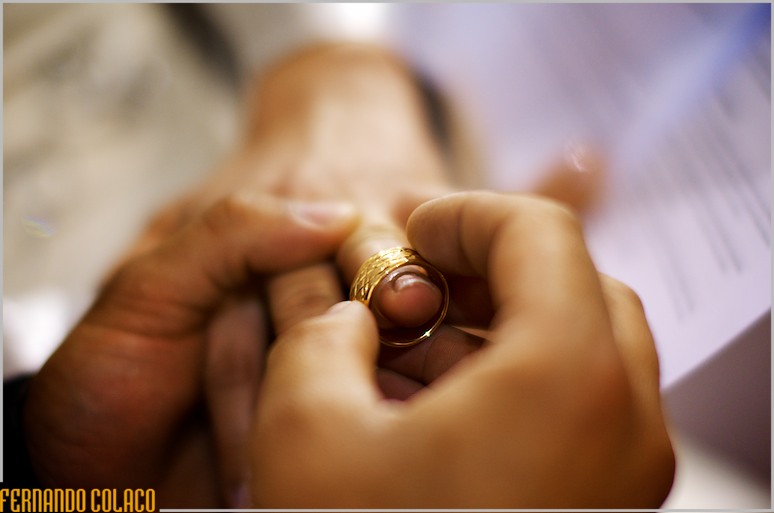 Detail of the ring, at the moment when the groom's hand puts it on the bride's finger.