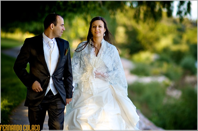 Walking and talking, the newly married couple, in a garden.
