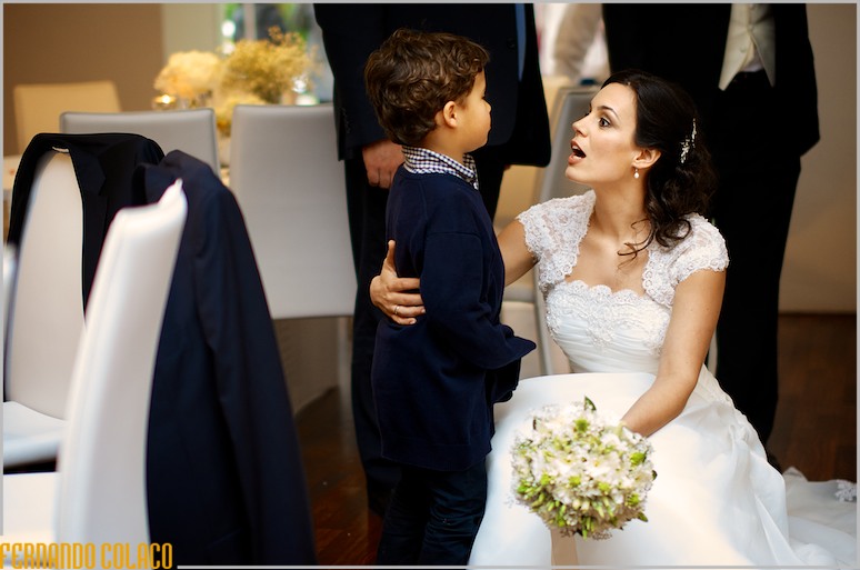 No espaço da festa do casamento, a noiva conversa com uma criança.
