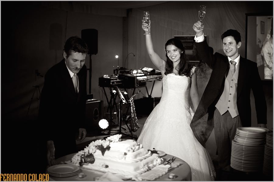 At the time of cutting the wedding cake, the bride and groom raise their glasses with champagne, toasting the guests.