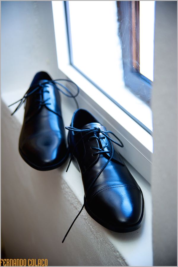 Os sapatos do noivo no parapeito de uma janela.
