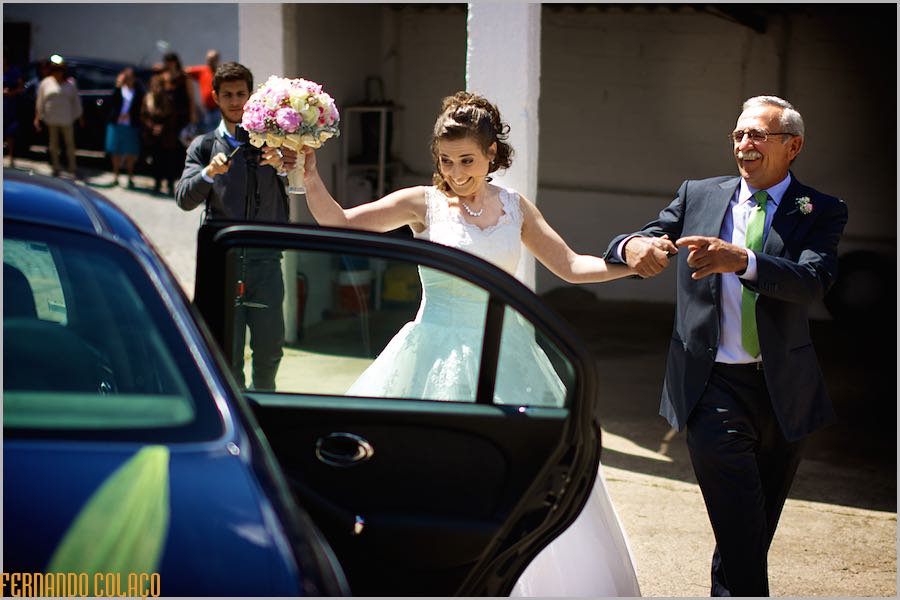 Festejando e pela mão do pai, a noiva prepara-se para entrar no automóvel para ir pra a cerimónia do casamento.