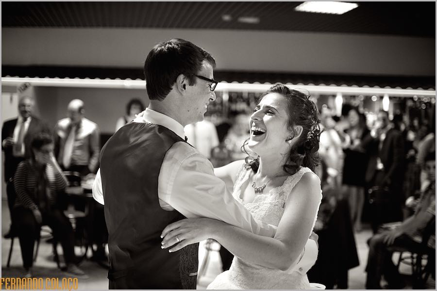 Os noivos riem muito, quando abrem o baile da festa do casamento.