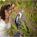 Among the cane fields, the bride puts her face to the groom's, laughing a lot, by the Évora wedding photographer.