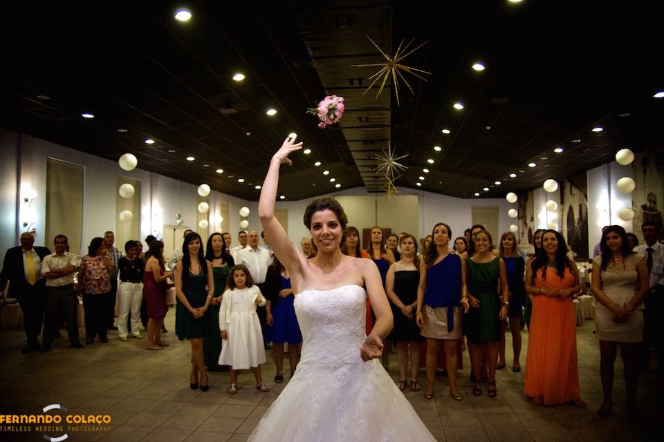 O momento em que a noiva atira o bouquet para ser apanhado pelas solteiras no casamento, atrás dela.
