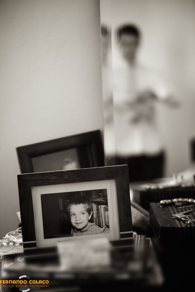 A portrait of the groom, in a frame on a piece of furniture, when he was a boy.