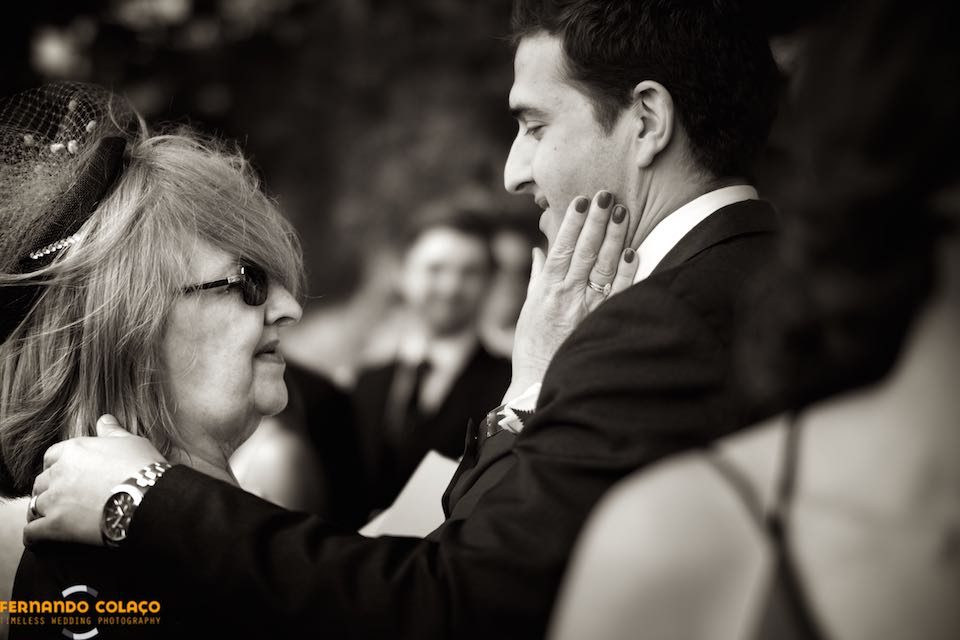 The groom's mother pats him on the cheek, as he leaves the wedding ceremony at the Church of S. Pedro de Penaferrim in Sintra.