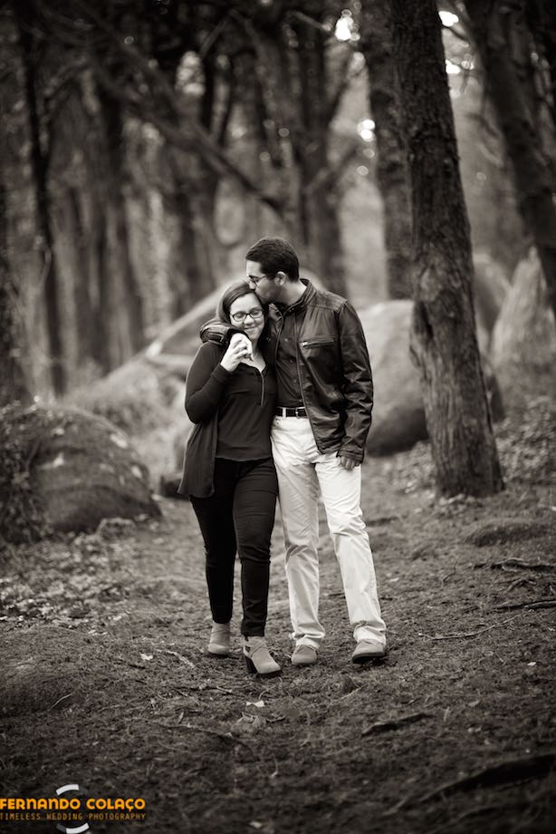 In the middle of the trees of the Sintra forest, the groom kisses the bride on the hair, as they walk.