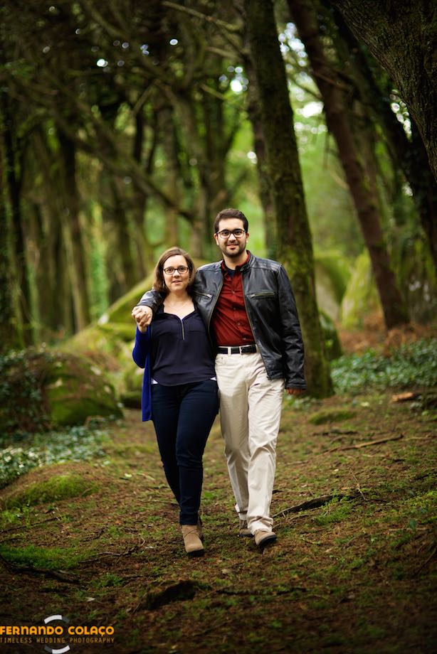 Strolling through the forest in Sintra, the bride and groom walk together, in a dating session with the wedding photographer.