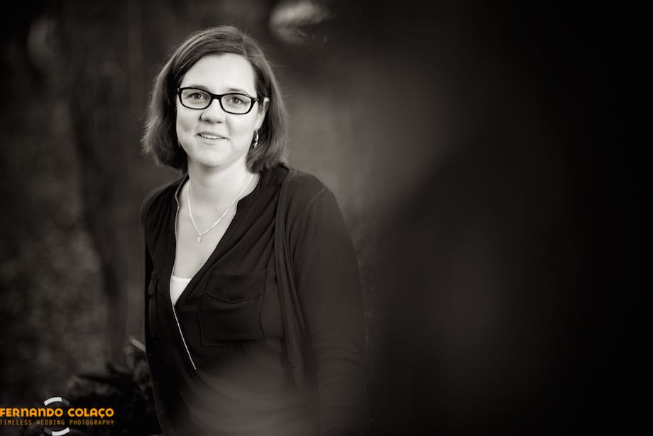Portrait of the bride, by the wedding photographer, in the midst of trees and plants of Sintra, out of focus.