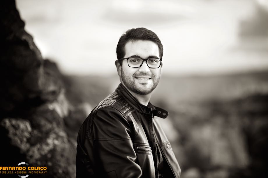 The black and white portrait of the groom, framed by the sky, the sea and the rocks of Guincho beach in Cascais.