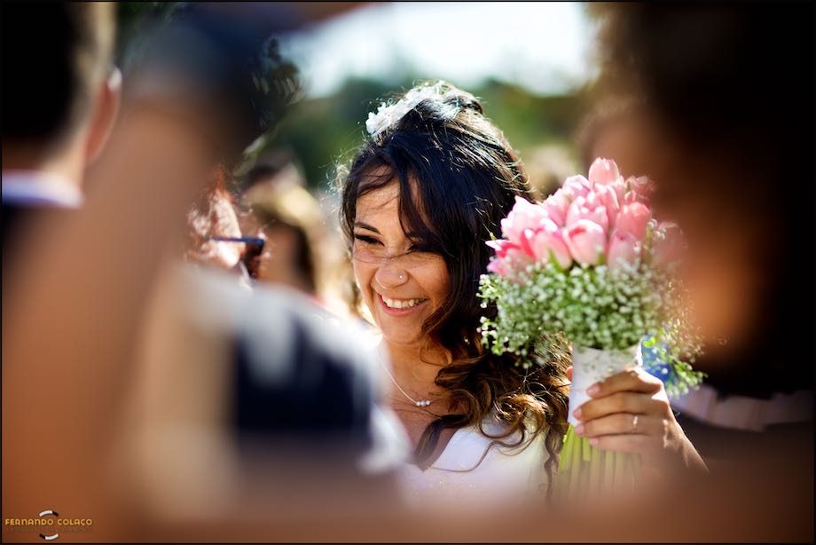 A noiva com o seu bouquet na mão recebe os parabéns.