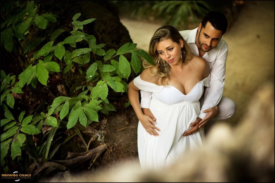 Casal entre as folhas de uma árvore.