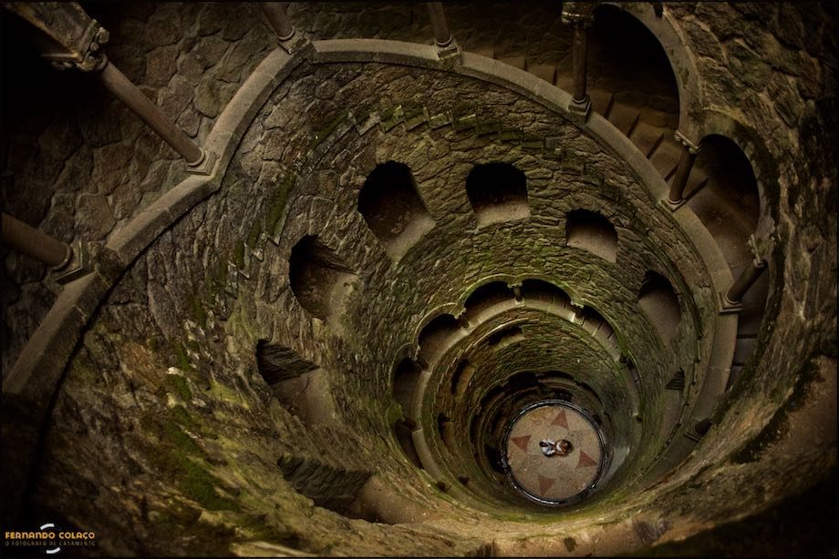 A casal no fundo da Torre Invertida na Quinta da Regaleira.