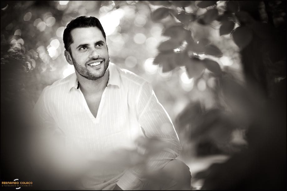 Homem entre folhas de árvores.