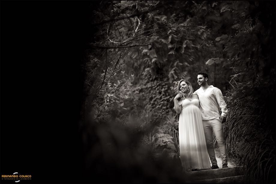 O casal passeia por entre árvores muito densas.