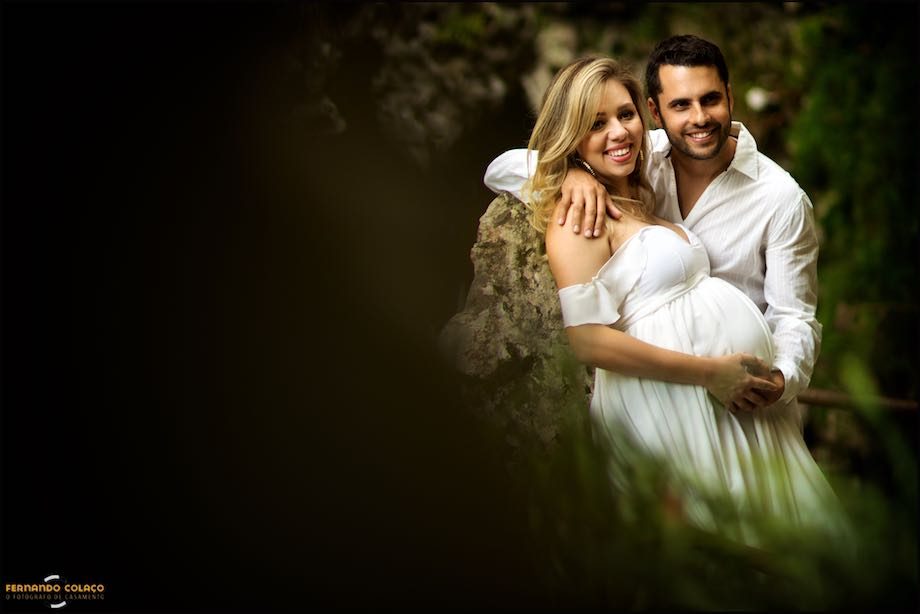 O casal de mãos dadas sob a barriga de grávida.