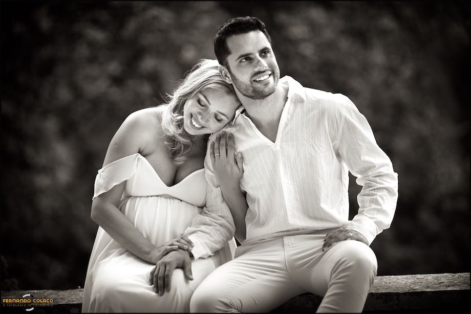 Mulher grávida encosta a cabeça no ombro do marido.