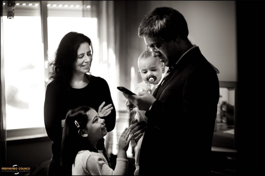 Pai, com o bebé ao colo, mãe e irmã em conversa.