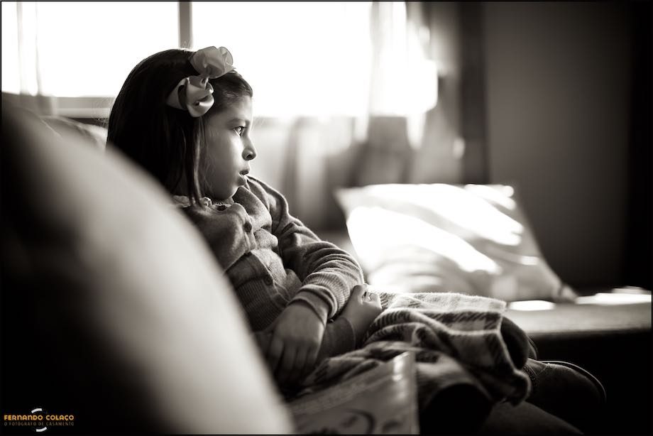 Menina, irmã do bebé, sentada à espera.