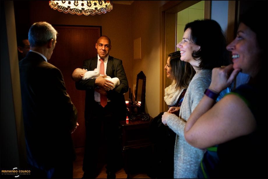 O padrinho do menino com ele ao colo junto do resto da família.