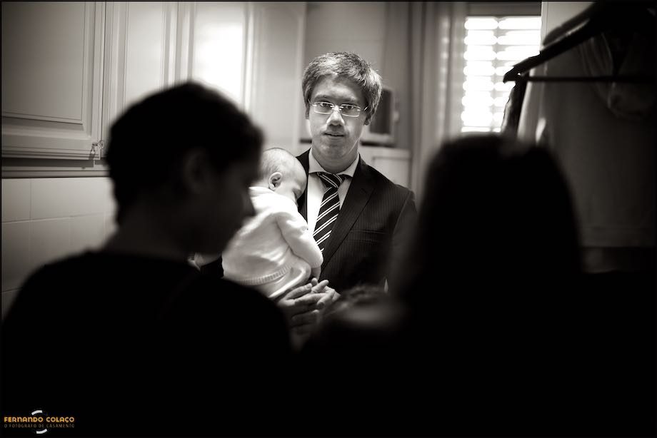 Pai do menino conversa com familiares, com ele ao colo.