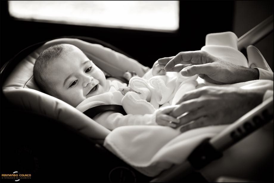 Bebé ri muito para as mãos que brincam com ele.