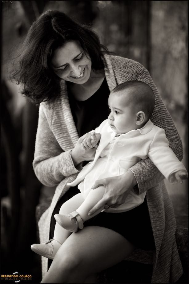 Mãe com o seu bebé ao colo no jardim e a preto e branco.