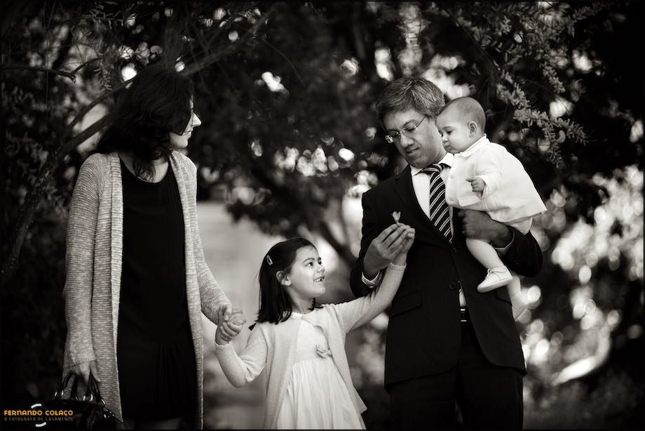 Família passeia pelo jardim depois da festa do batizado.