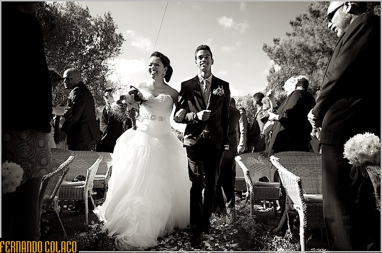 A noiva, de braço dado com o seu filho mais velho, percorre o caminho entre os convidados até mesa da cerimónia do casamento.