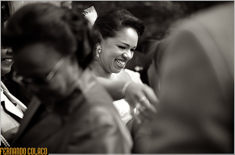 A noiva sorrindo feliz, no meio de convidados do casamento que a felicitam, na Quinta do Roseiral.