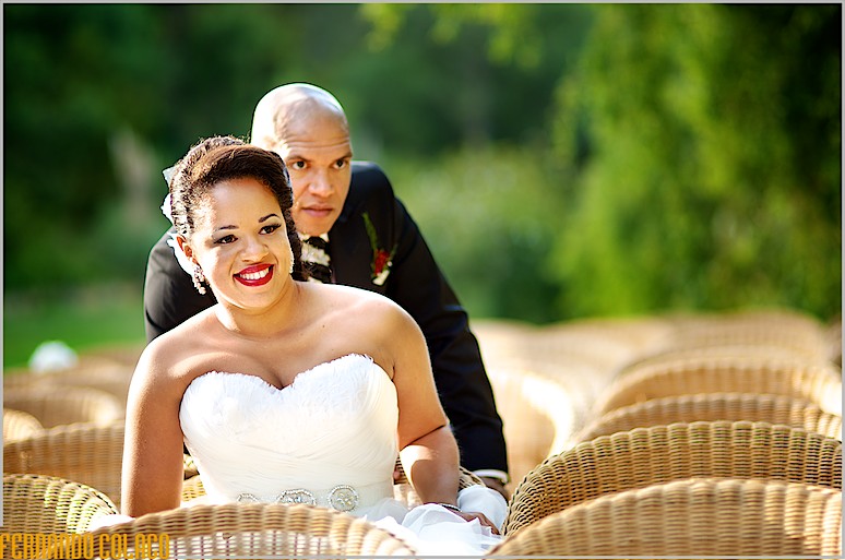 Sentados nas cadeiras da cerimónia do casamento, o casal olham frente.