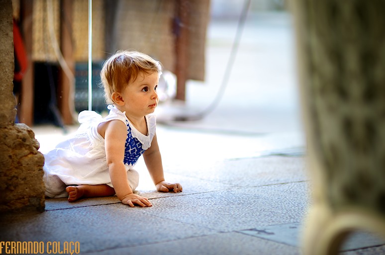 Menina, ainda bebé, gatinha pelo chão.