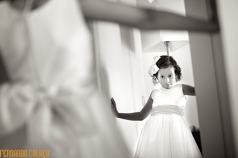 A filha dos noivos olha-se ao espelho depois de vestida para o casamento.