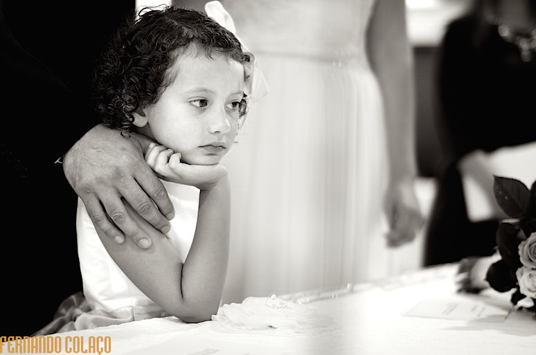 A filha dos noivos com o cotovelo na mesa da cerimónia do casamento na Quinta de D. Nuno em Fátima, apoia a cara na mão.
