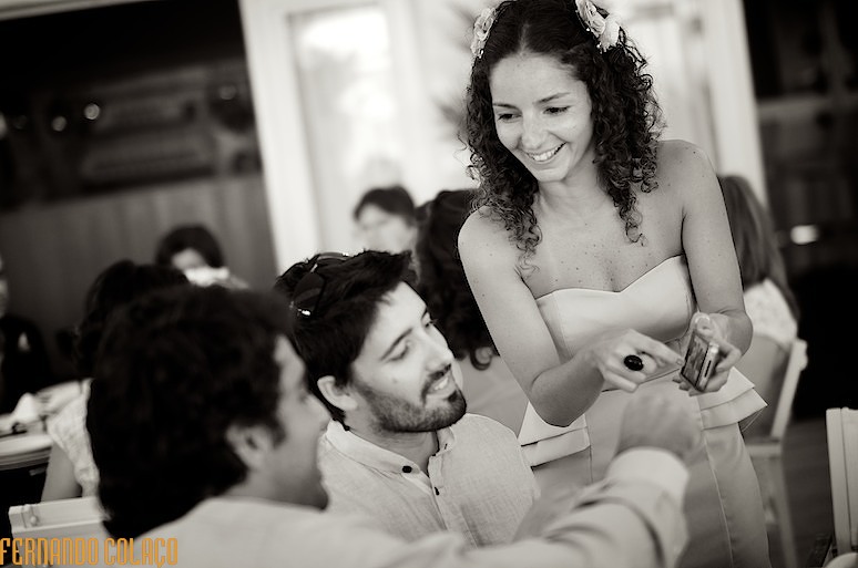 A she wedding guest shows a photo on her cell phone to two friends.