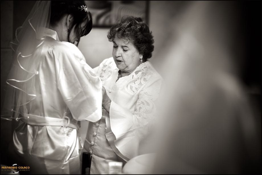 The bride with her mother who helps her with the dress.
