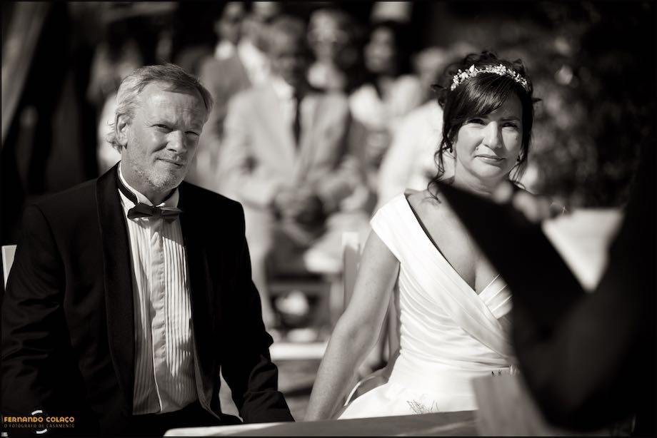 The bride and groom, seated side by side, facing the ceremonial table of the wedding at Morada do Sol in Sintra.