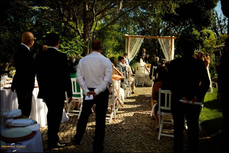 View of the wedding ceremony site at Morada do Sol in Sintra, with the guests in the back and the bride and groom in the background.