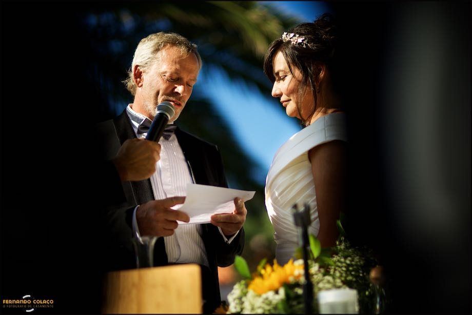 The groom reading his vows, with the bride in front of him at the wedding ceremony.