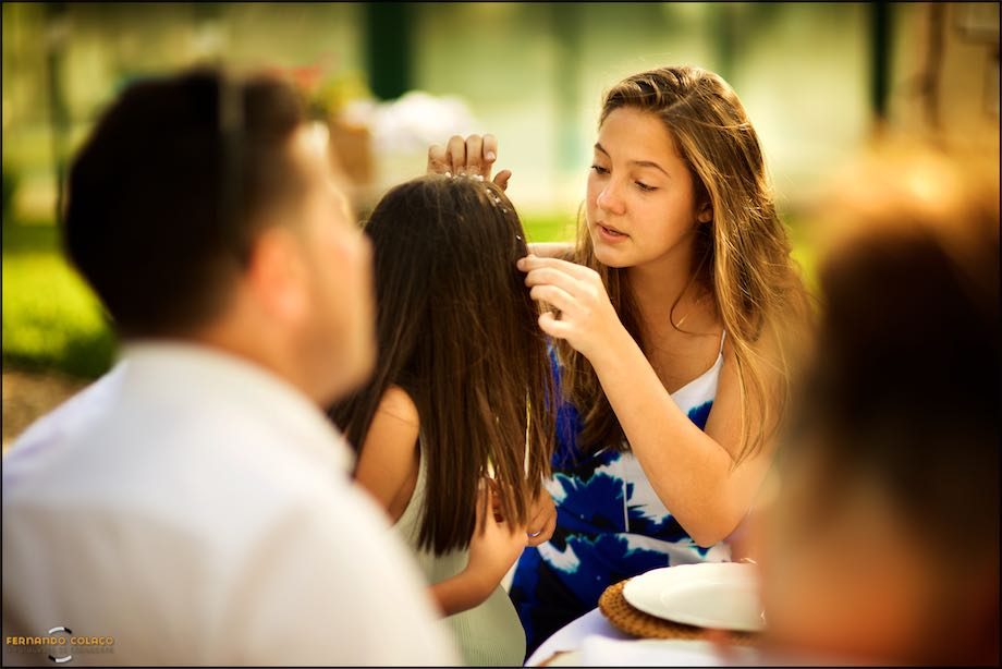 A wedding guest fixes a tiara in a girl's hair.
