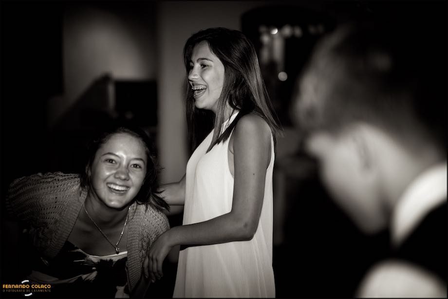 Two girls, at the wedding party, laugh a lot with each other.