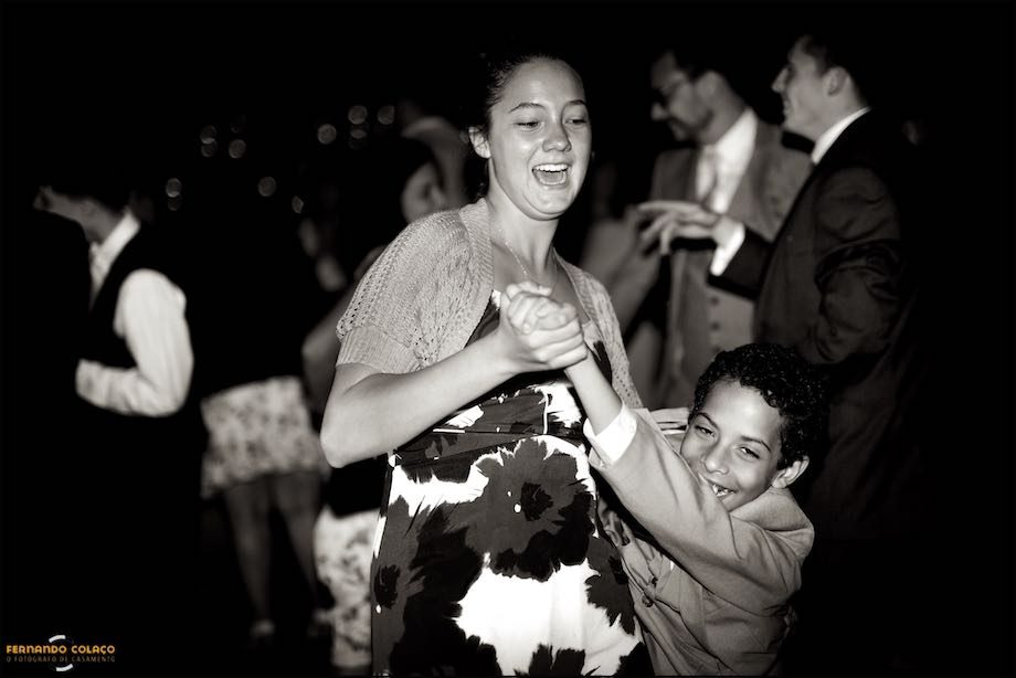 A girl and a boy playfully dance during the wedding party.